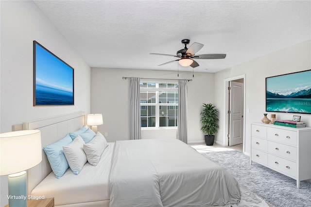 bedroom with a textured ceiling, ceiling fan, and light colored carpet