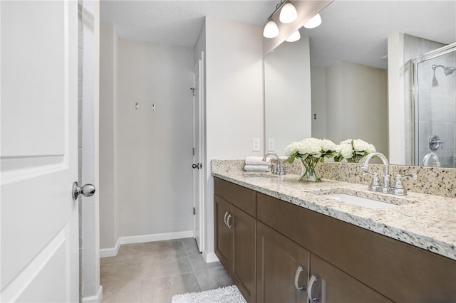 bathroom with walk in shower, vanity, and tile patterned floors