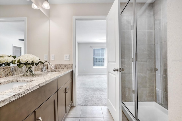 bathroom featuring vanity, a shower with door, and tile patterned floors