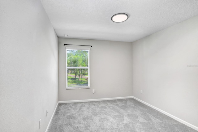 unfurnished room with light carpet and a textured ceiling