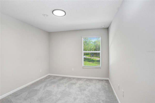 unfurnished room featuring light carpet and a textured ceiling