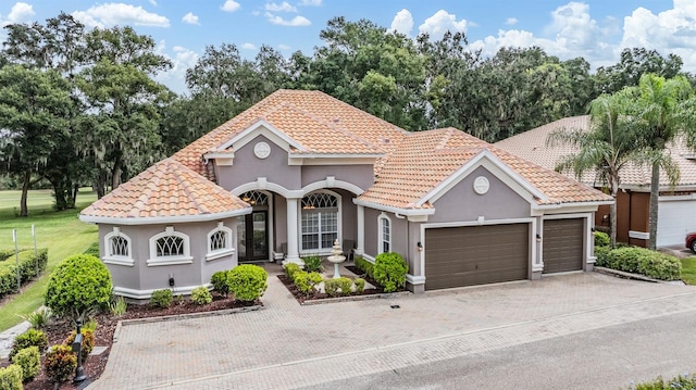 mediterranean / spanish house with a front yard and a garage