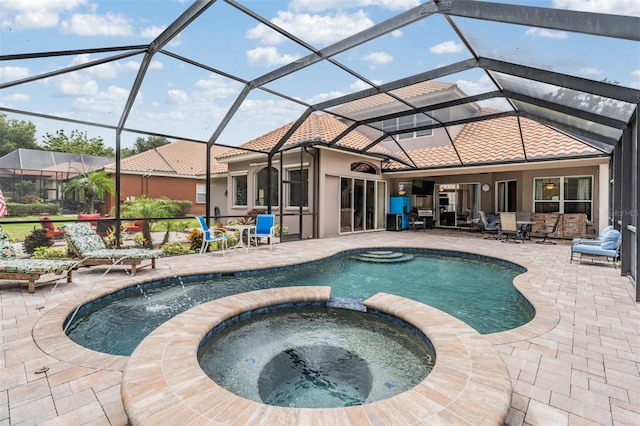 view of pool with an in ground hot tub, a lanai, and a patio area