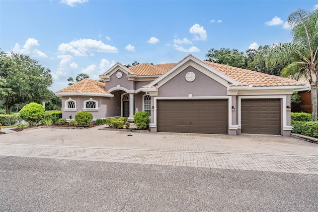 mediterranean / spanish-style home with a garage