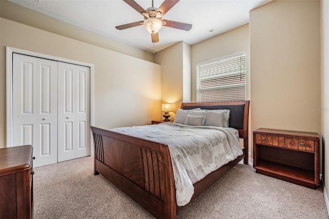 bedroom featuring a ceiling fan, a closet, and light colored carpet