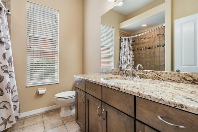 bathroom featuring tile patterned flooring, curtained shower, vanity, and toilet