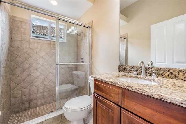 bathroom with vanity, a shower with shower door, toilet, and tile patterned flooring