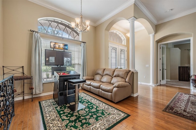 living room with arched walkways, crown molding, decorative columns, and wood-type flooring