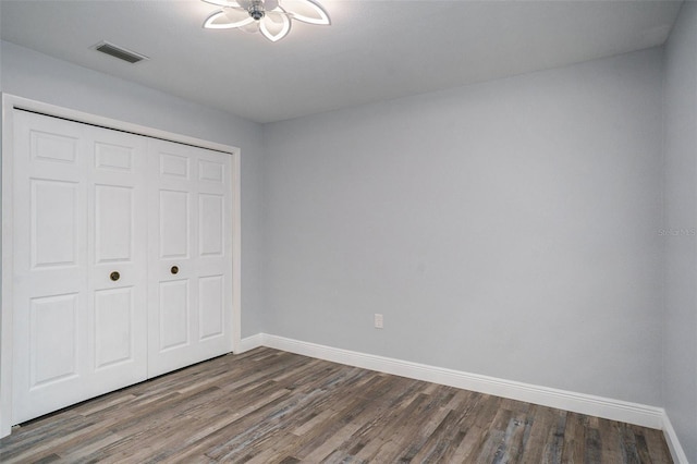 unfurnished bedroom featuring a closet and dark hardwood / wood-style floors