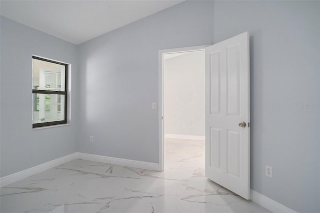 unfurnished room with vaulted ceiling