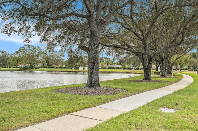 surrounding community featuring a water view and a lawn