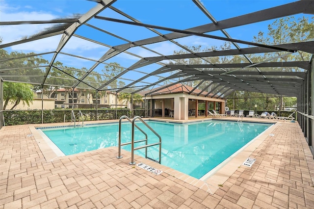 view of swimming pool featuring a patio and glass enclosure