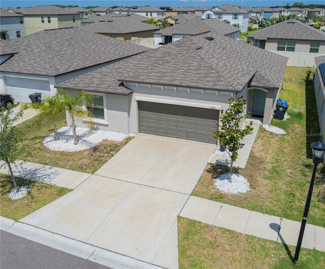 ranch-style house featuring a front yard and a garage