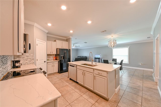 kitchen with sink, ceiling fan with notable chandelier, an island with sink, appliances with stainless steel finishes, and ornamental molding