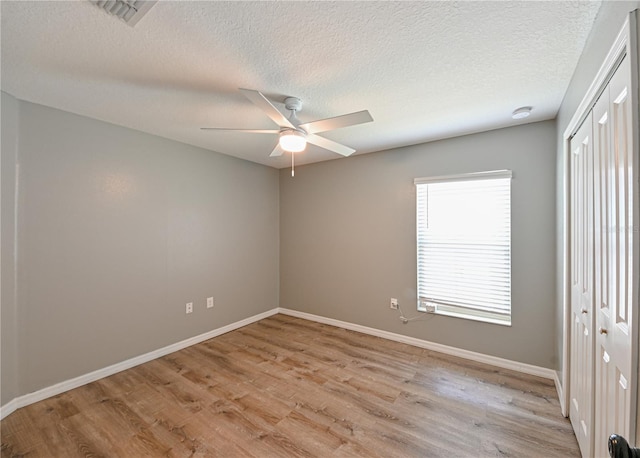 unfurnished room featuring a textured ceiling, ceiling fan, and light hardwood / wood-style flooring