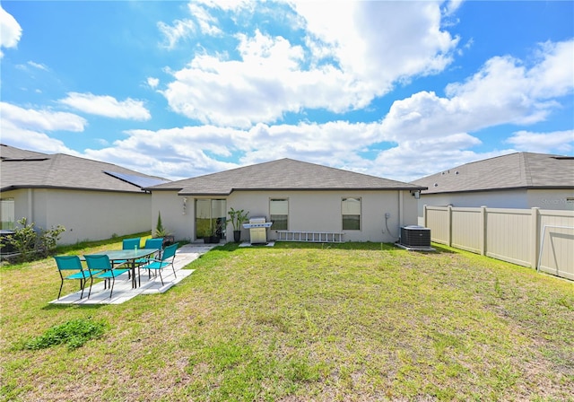 rear view of property with a patio, cooling unit, and a yard