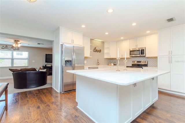 kitchen featuring ceiling fan, light stone counters, dark wood-type flooring, white cabinetry, and appliances with stainless steel finishes