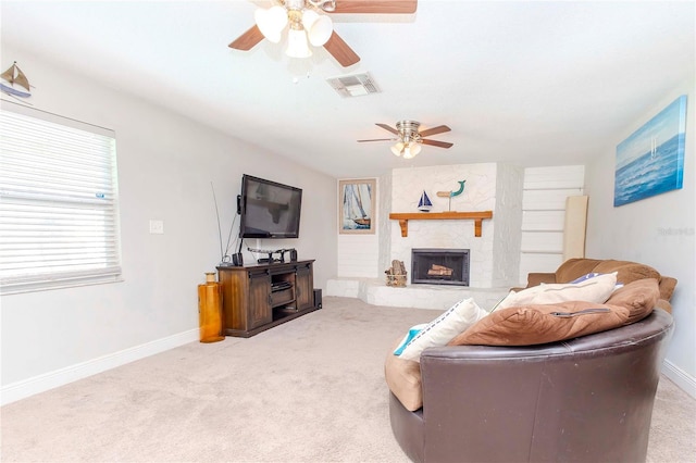 living room featuring carpet, ceiling fan, and a fireplace