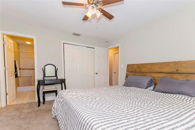 bedroom featuring ceiling fan, light colored carpet, a closet, and ensuite bathroom