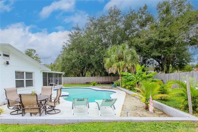 view of swimming pool with a patio and a sunroom