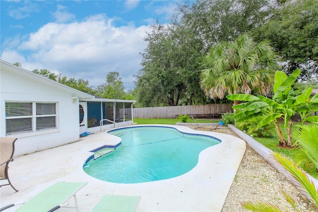 view of pool with a sunroom and a patio area