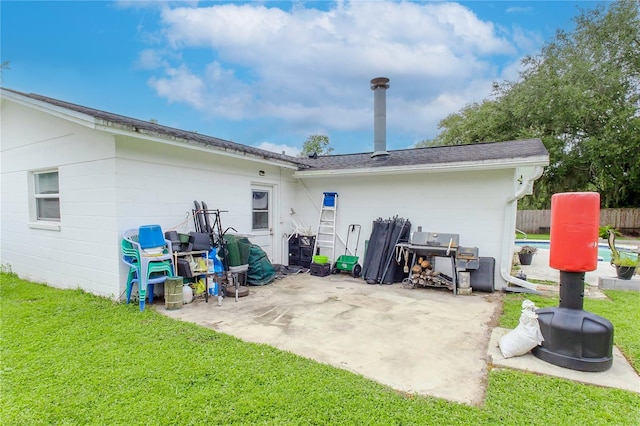 rear view of house featuring a yard and a patio