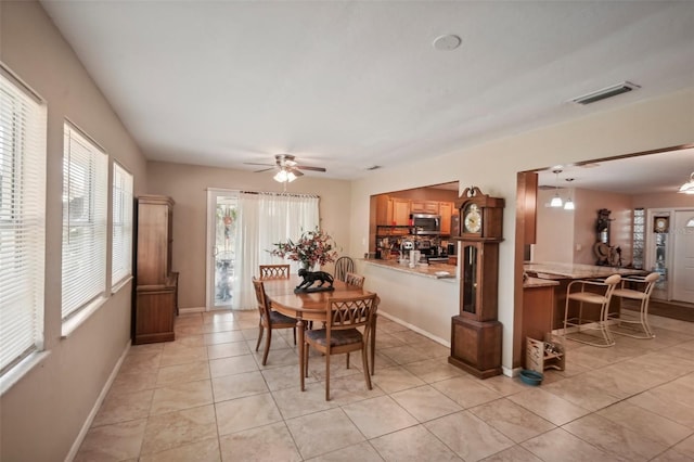 tiled dining area featuring ceiling fan