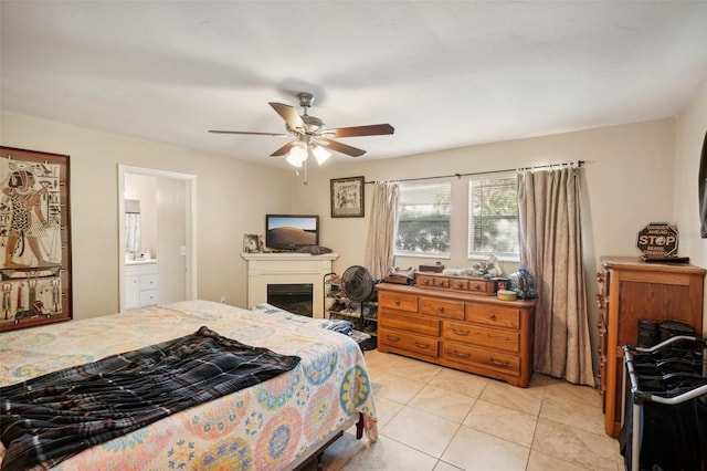 bedroom with ensuite bath, ceiling fan, a fireplace, and light tile patterned flooring