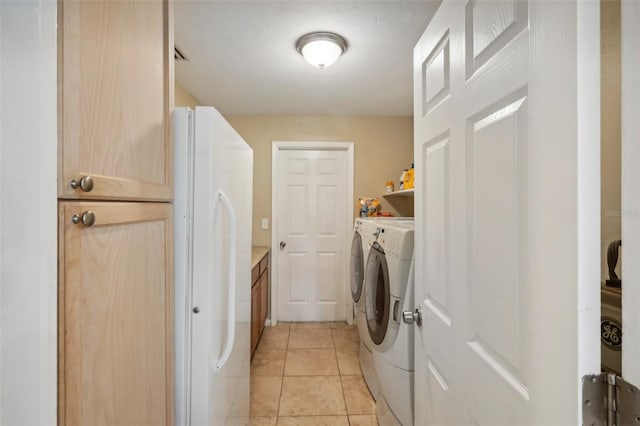 clothes washing area featuring light tile patterned flooring and independent washer and dryer