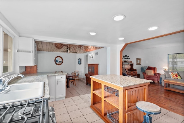 kitchen featuring ceiling fan, light tile patterned floors, and white cabinetry