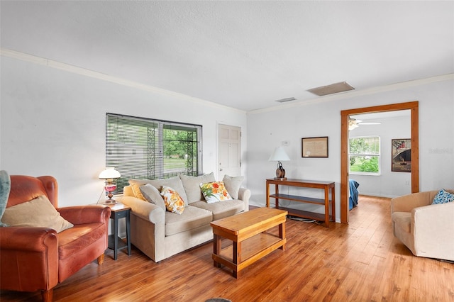 living room featuring ornamental molding, ceiling fan, light hardwood / wood-style flooring, and a wealth of natural light