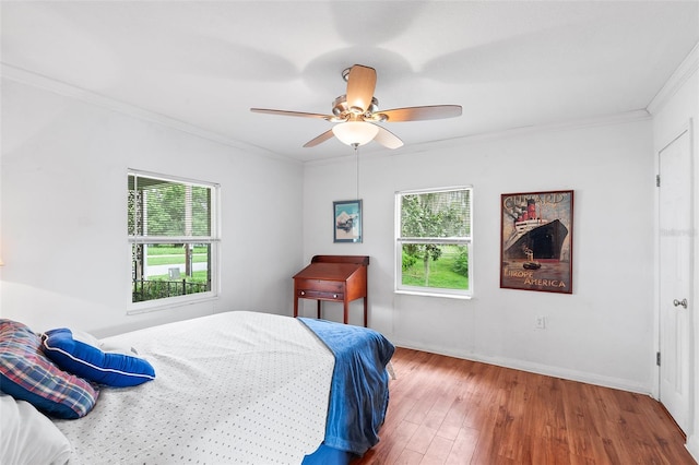 bedroom featuring ceiling fan, crown molding, and wood-type flooring