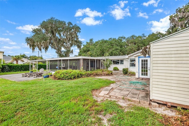 back of house with a patio, a lawn, and a sunroom