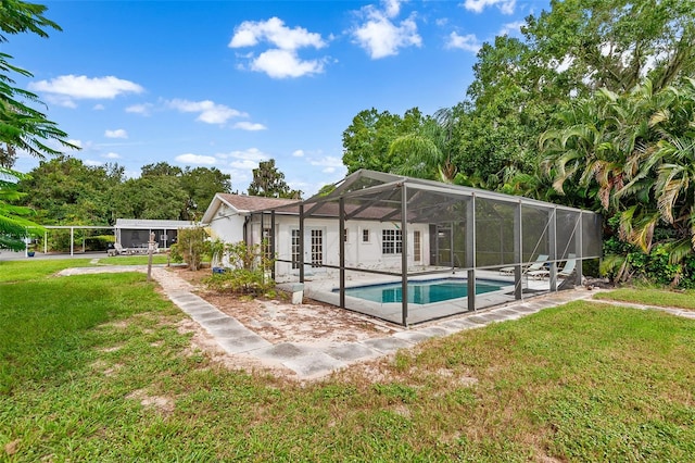 view of swimming pool featuring a yard, glass enclosure, and a patio area