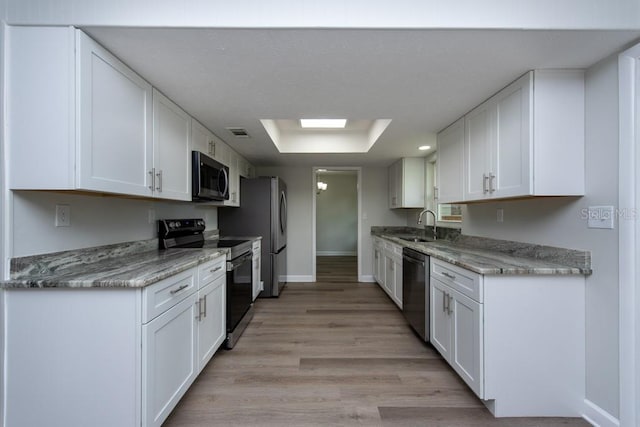 kitchen featuring white cabinets, light stone counters, and stainless steel appliances