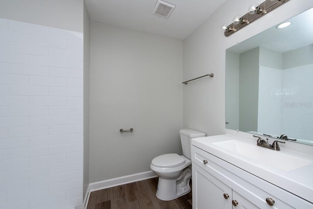 bathroom with wood-type flooring, vanity, and toilet