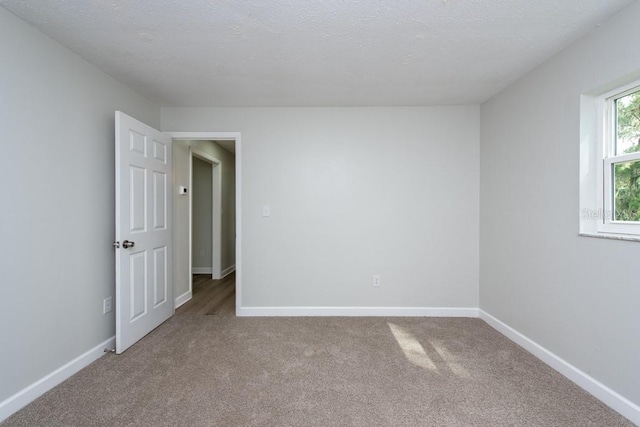 empty room featuring a textured ceiling and carpet floors