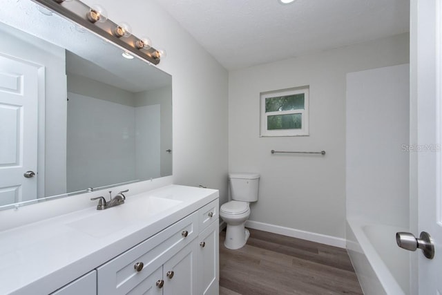 bathroom featuring hardwood / wood-style floors, vanity, a textured ceiling, and toilet