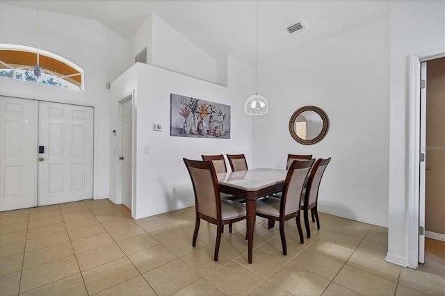 tiled dining room with high vaulted ceiling