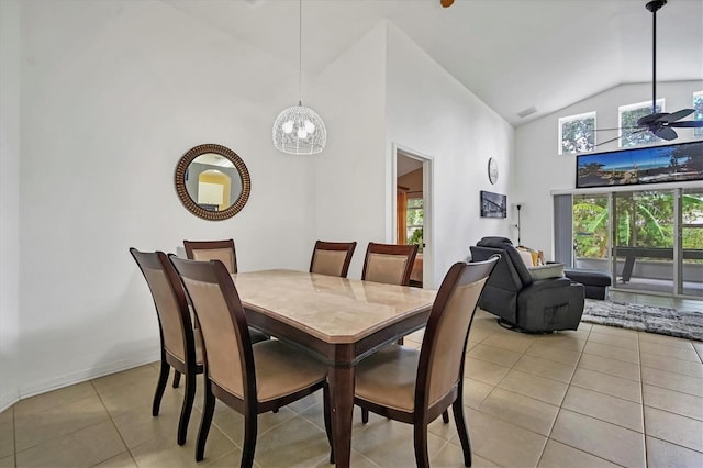 dining area with high vaulted ceiling, a notable chandelier, and light tile patterned floors