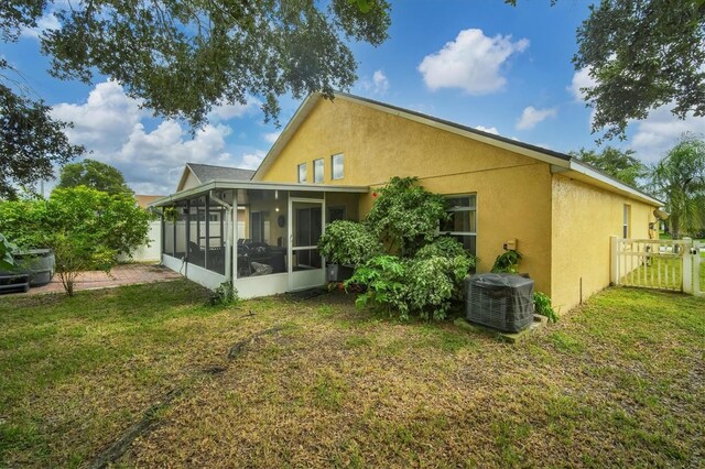 1122 Vinetree Dr, Brandon, FL 33510 - back of house with a sunroom, central air condition unit, fence, a lawn, and stucco siding