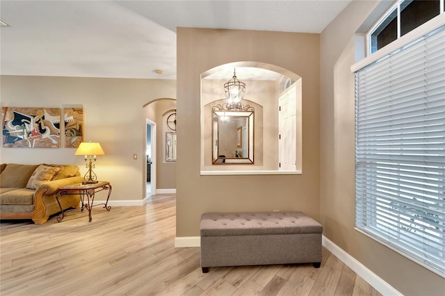 living area featuring light hardwood / wood-style flooring and a chandelier