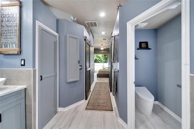 bathroom featuring vanity, toilet, a textured ceiling, and hardwood / wood-style flooring