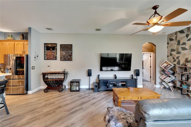 living room with ceiling fan and light hardwood / wood-style flooring