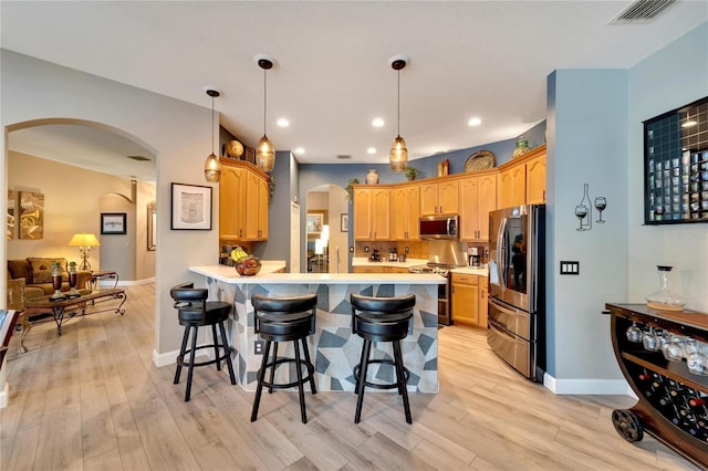 kitchen with light hardwood / wood-style flooring, appliances with stainless steel finishes, and hanging light fixtures