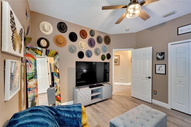 living room with ceiling fan and light hardwood / wood-style flooring