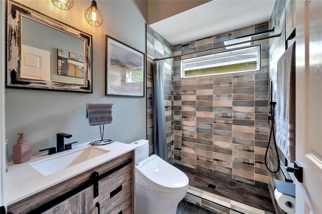 bathroom featuring a tile shower, vanity, and toilet