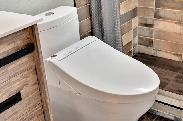 bathroom featuring vanity, toilet, a textured ceiling, and curtained shower