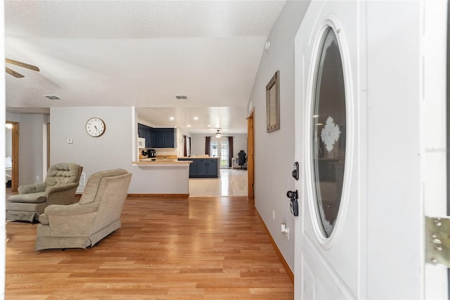 foyer with ceiling fan, hardwood / wood-style floors, and a textured ceiling