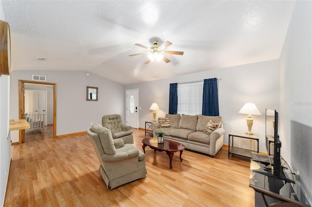 living room with ceiling fan, vaulted ceiling, a textured ceiling, and hardwood / wood-style floors